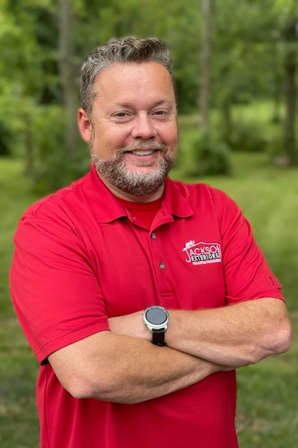 Jackson Exteriors owner outdoors in his red company polo shirt